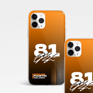Könnte beinhalten: Orangefarbene und schwarze iPhone-Hülle mit einer weißen Nummer 81 und einer Unterschrift. Die Hülle trägt außerdem den aufgedruckten Text "Oscar Piastri McLaren".
