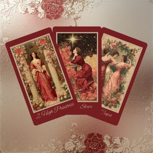 May include: Three tarot cards with burgundy borders. The cards feature vintage illustrations of women in flowing gowns amidst floral backgrounds. The cards are labeled "2 High Priestess", "Star", and "Cups". The background has floral and lace patterns.