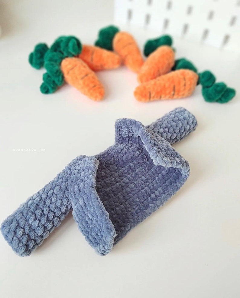Puede incluir: Una chaqueta de punto azul con mangas largas y una superficie texturizada.