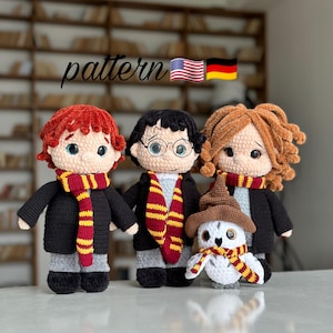 May include: Crocheted dolls of three characters and an owl, each wearing a scarf and a black robe. The dolls have different hair colors and facial features. The word "pattern" is written in cursive above the dolls, with the American and German flags next to it.