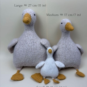 May include: Three knitted goose toys in varying sizes. The largest is approximately 11 inches tall, the medium is 7 inches, and the smallest is 4 inches. Each goose has a gray body, yellow beak and feet, and small black eyes. The text on the image indicates the size of each goose.
