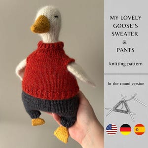 Könnte beinhalten: Eine handgestrickte Gänsepuppe mit rotem Pullover und grauer Hose. Die Gans hat einen weißen Kopf, einen gelben Schnabel und Füße sowie weiße Flügel. Das Bild enthält den Text "MY LOVELY GOOSE'S SWEATER & PANTS knitting pattern."