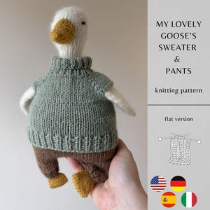Puede incluir: Un juguete de ganso tejido con un suéter verde salvia y pantalones marrones, con un pico amarillo. El texto dice: MY LOVELY GOOSE'S SWEATER & PANTS knitting pattern, flat version. Incluye un dibujo lineal de un cuadrado tejido y cuatro iconos de banderas.