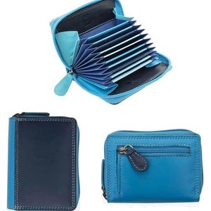 May include: A collection of blue leather wallets. One wallet is open, revealing multiple card slots. Another wallet is closed, showing a dark blue front with light blue sides. The third wallet is a lighter blue with a zipper and a small pocket.