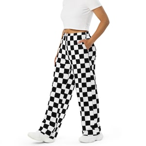 May include: A person wearing a white crop top and black and white checkered pants.
