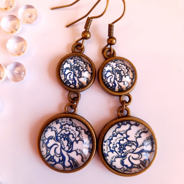 Boucles d'oreilles pendantes. Cabochons en verre. Motif floral bleu et blanc