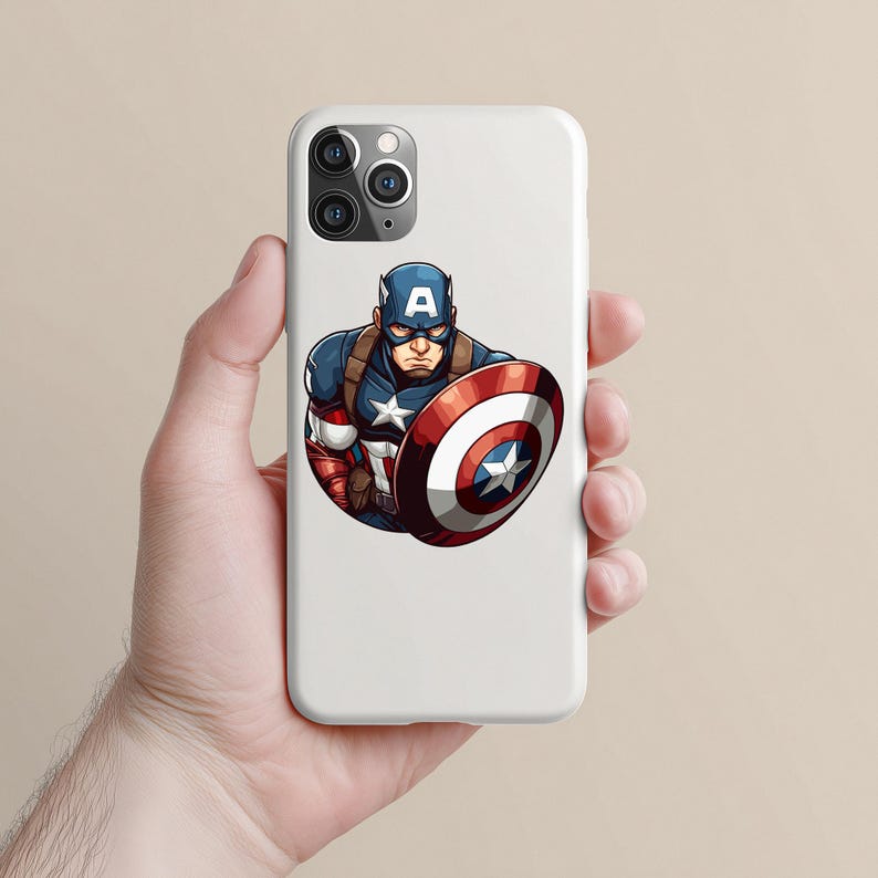以下が含まれることがあります： キャプテン・アメリカのグラフィックが描かれた白い携帯電話ケース。イラストは、キャプテン・アメリカが青、赤、白の象徴的なコスチュームを着て、シールドを持っている様子を描いています。シールドは、中央に星がある赤と白の円形デザインです。