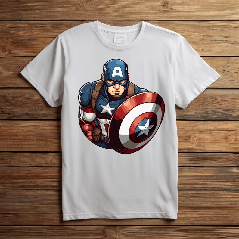 以下が含まれることがあります： キャプテン・アメリカのグラフィックが描かれた白いTシャツ。イラストは、キャプテン・アメリカが象徴的な青、赤、白のコスチュームを着て、盾を持っている様子を描いています。盾は、中央に白い星が付いた赤と白のストライプのデザインです。