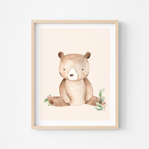 May include: A watercolor illustration of a brown bear sitting on a log with green leaves and white flowers. The background is a light peach color.