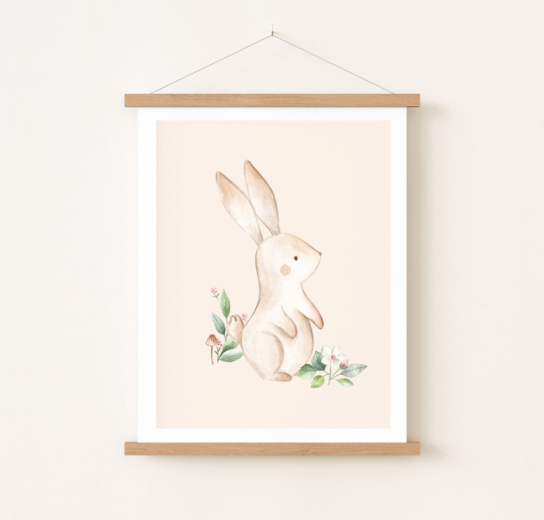 May include: A watercolor illustration of a brown bunny rabbit standing on a peach background with green leaves and pink flowers.