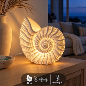 Pode incluir: Uma lâmpada em forma de concha branca com superfície texturizada que emite um brilho interno quente. A lâmpada apresenta um design em espiral e é alimentada por um conector USB. Um gráfico indica que a lâmpada mede 30,48 cm de altura.