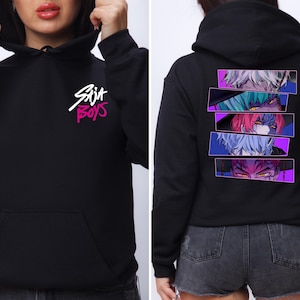 May include: Black hoodie with a front pocket and hood. The front features the text "Skit Boys" in white and pink. The back displays a graphic of anime eyes in rectangular panels with purple borders.