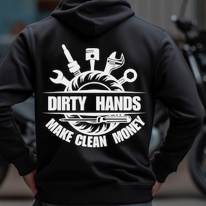 Puede incluir: Sudadera con capucha negra con un gráfico blanco que presenta herramientas y el texto "DIRTY HANDS MAKE CLEAN MONEY". El diseño incluye una llave inglesa, una bujía, un pistón y un destornillador. La sudadera tiene una capucha con cordón y un bolsillo delantero.