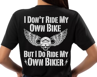 May include: Black t-shirt with white text that reads "I don't ride my own bike, but I do ride my own biker" with a skull wearing a helmet and wings behind the text.
