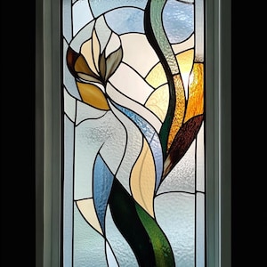 Puede incluir: Una ventana de vitrales con un diseño abstracto moderno que presenta una flor estilizada con piezas de vidrio amarillo, verde, azul y marrón.