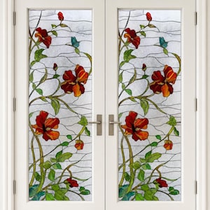 May include: A set of double white doors featuring stained glass inserts with a repeating pattern of red flowers, green leaves, and small blue butterflies. The glass has a textured, frosted appearance with dark leaded lines outlining the design.
