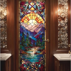 May include: A stained glass door depicting a landscape with a sunset, mountains, and a lake. The artwork uses a variety of colours, including yellow, orange, blue, and purple. The door is framed in dark wood and has a gold-coloured handle.