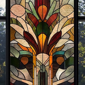 Puede incluir: Una vidriera con un diseño floral. La ventana presenta un patrón simétrico con una flor central en tonos rojos, naranjas y verdes. El fondo es una mezcla de beige, marrón y amarillo, con líneas negras que separan los trozos de vidrio.