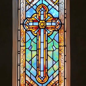 May include: A stained glass window featuring a central cross design. The cross is primarily red, orange, and yellow, set against a backdrop of blue and green glass. The window is framed in a white border.