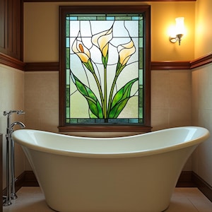 Peut inclure: Une baignoire blanche et autoportante est placée devant une fenêtre en vitrail. La fenêtre présente un motif floral avec des callas jaunes et des feuilles vertes. La salle de bain a une ambiance chaleureuse et accueillante.