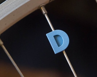 Letter "D" Bike Spoke Decoration. Fits on bicycle wheel spokes. This accessory clips onto bike spokes like spoke beads. Made in USA.