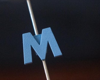 Letter "M" Bike Spoke Decoration. Fits on bicycle wheel spokes. Accessory clips onto bike spokes like spoke beads. Made in USA.