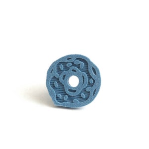 Peut inclure: Un charme bleu en forme de beignet avec un trou blanc au centre et un gla&ccedil;age blanc.