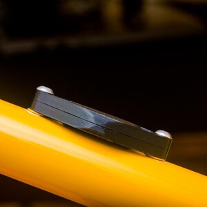 Side view of the Bicycle AirTag mount showing the AirTag hidden inside the compartment.