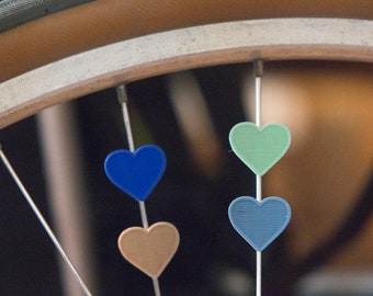 4 pack Heart bike spoke decoration for bicycle wheels. Colors available, like spoke charms beads. Bike accessory clips on spokes.