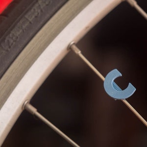 Bike Spoke Decoration Letter &quot;C&quot;. Fits on bicycle wheel spokes. This accessory clips onto bike spokes like spoke beads. Made in USA.