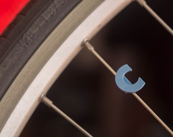 Bike Spoke Decoration Letter "C". Fits on bicycle wheel spokes. This accessory clips onto bike spokes like spoke beads. Made in USA.