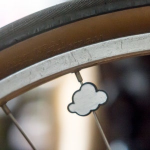 Cute cloud bike spoke decoration. Fits on bicycle wheel spokes. Accessory clips on bike spokes like spoke beads. Made in USA