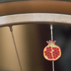 Pomegranate fruit bike spoke decoration. Fits bikes, wheelchairs. Accessory clips on like spoke decorations, beads, charms.