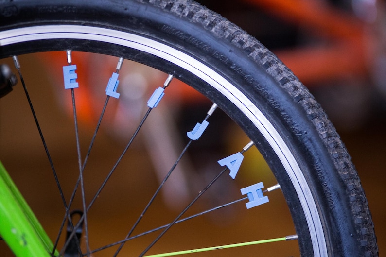 Bike Spoke Decoration Letters. 6 letter set. Fits on bicycle wheel spokes. Accessory clips onto bike spokes like spoke beads. Made in USA. image 1