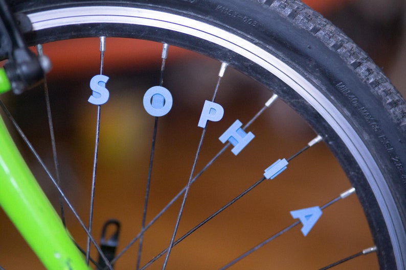 Bike Spoke Decoration Letters. 6 letter set. Fits on bicycle wheel spokes. Accessory clips onto bike spokes like spoke beads. Made in USA. image 2