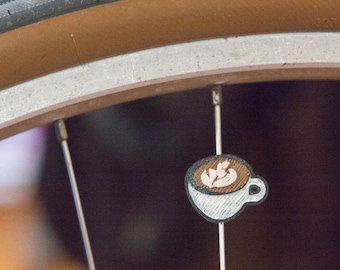 Latte art espresso / coffee spoke decoration. Fits on bicycle wheels. Accessory clips on like spoke beads & ornaments, charms. Made in USA