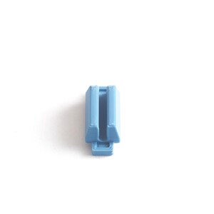 May include: A light blue plastic connector with a slot in the middle.