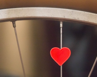 Heart spoke decoration for bicycle wheel spokes. Color options, accessory clips on bike spokes and wheelchairs like spoke beads. Made in USA