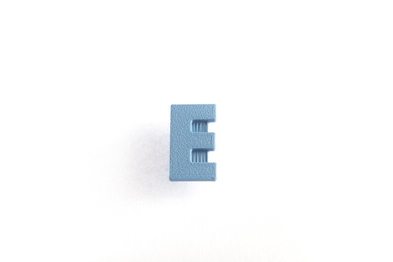 May include: A light blue plastic letter E.
