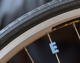 Letter "E" Bike Spoke Decoration. Fits on bicycle wheel spokes. This accessory clips onto bike spokes like spoke beads. Made in USA.