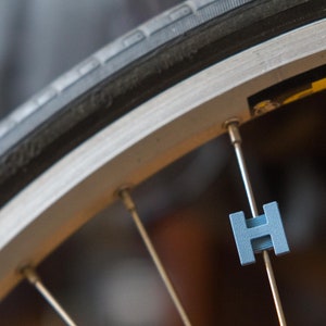 Letter &quot;H&quot; Bike Spoke Decoration. Fits on bicycle wheel spokes. Accessory clips onto bike spokes like spoke beads. Made in USA.