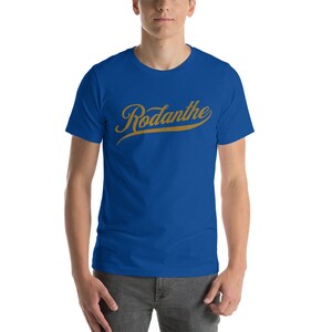 May include: A royal blue t-shirt with a gold cursive word "Rodanthe" on the front.