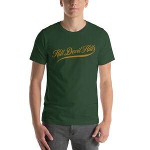 May include: A dark green t-shirt with a gold script design that reads "Kill Devil Hills".