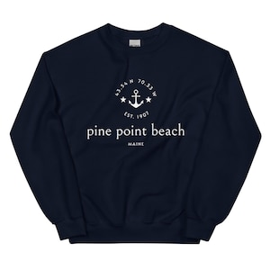 Könnte beinhalten: Marineblaues Sweatshirt mit weißem Text und Grafik. Das Design umfasst einen Anker, Sterne und die Worte "pine point beach maine" mit Koordinaten und "est. 1907". Ein bequemes, lässiges Oberteil.