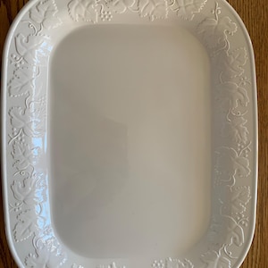 May include: White ceramic serving platter with a raised design of grape leaves around the edge.