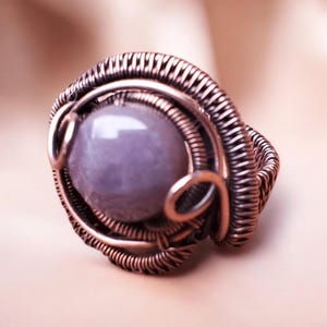 Peut inclure: Une bague en fil de fer avec une grande pierre précieuse ovale de couleur violet clair.