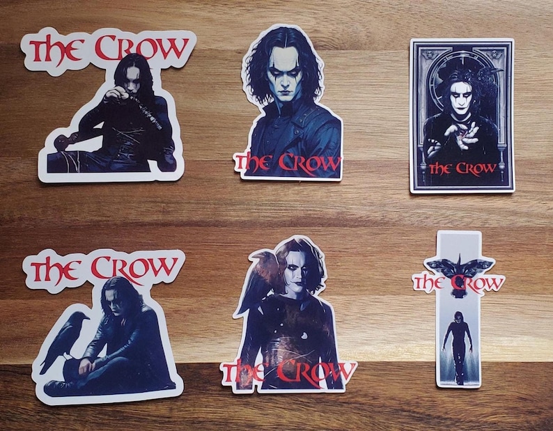 May include: Set of six The Crow stickers featuring the character Eric Draven, a crow, and the title text. The stickers are printed on white paper with black and red text.
