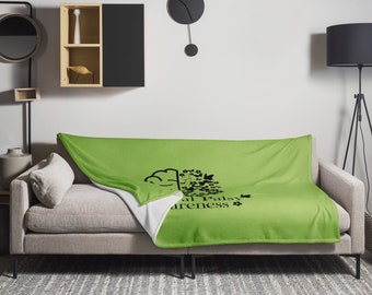 Op de afbeelding: Groene en witte deken met een zwart breinontwerp en de tekst "Cerebral Palsy Awareness".