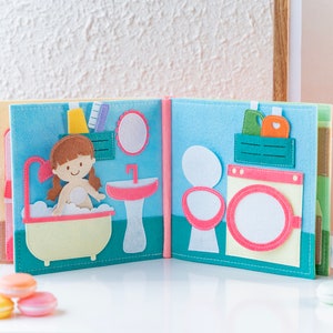 Page 3 and page 4 of dollhouse quiet book, square shaped, made from felt, light and soft, pastel tone colors, with little girl in bathroom sink, wash basins, mirror, laundry room with washing machine and washing liquid