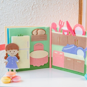 page 5 and page 6 of dollhouse quiet book, square shaped, felt material, light and soft, simulates kitchen room, with refrigerator white color is close, 1 dining table pastel pink, kitchen tools on pastel pink and violet